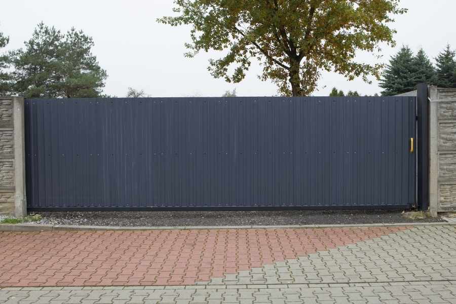 Clôture aluminium anthracite coulissante avec piliers en pierre et pavage décoratif