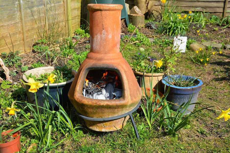 Une cheminée en terre cuite dans un jardin printanier pour illustrer comment fabriquer son propre garum de légumes pour remplacer le sel et les bouillons.