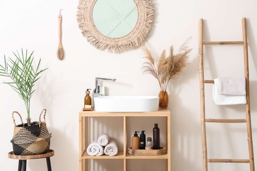 Une étagère en bois clair sert de meuble de salle de bain dans une ambiance bohème et naturelle.